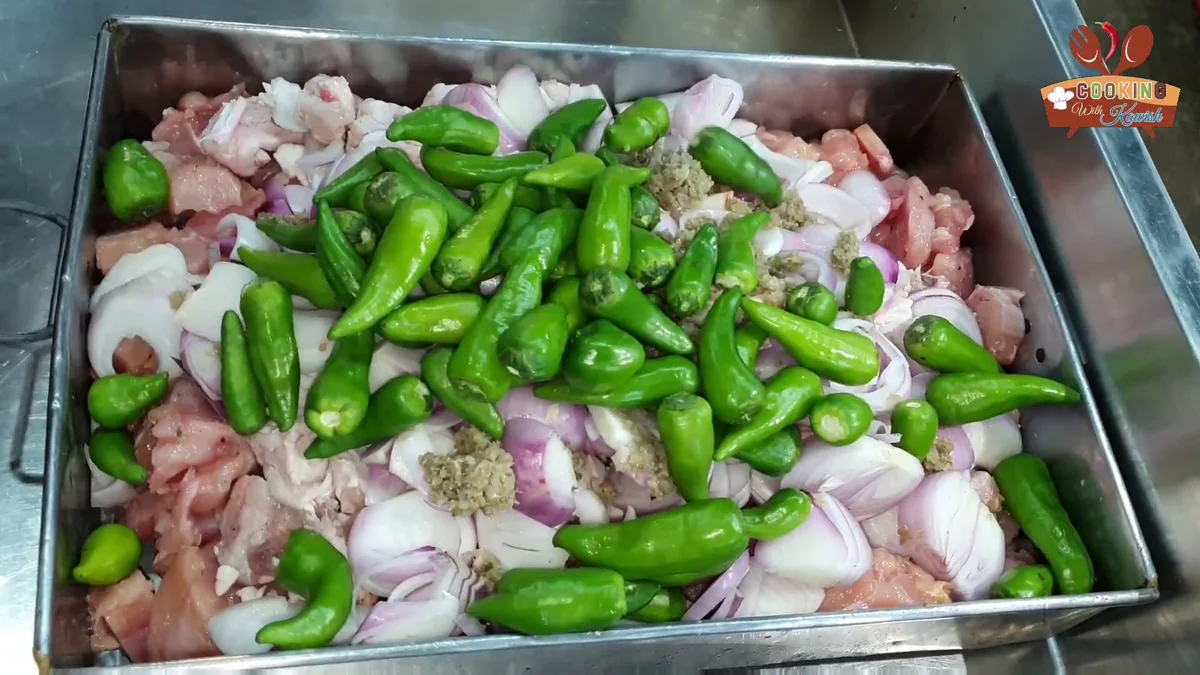 Whole green chillies added to the chicken, fat and onions