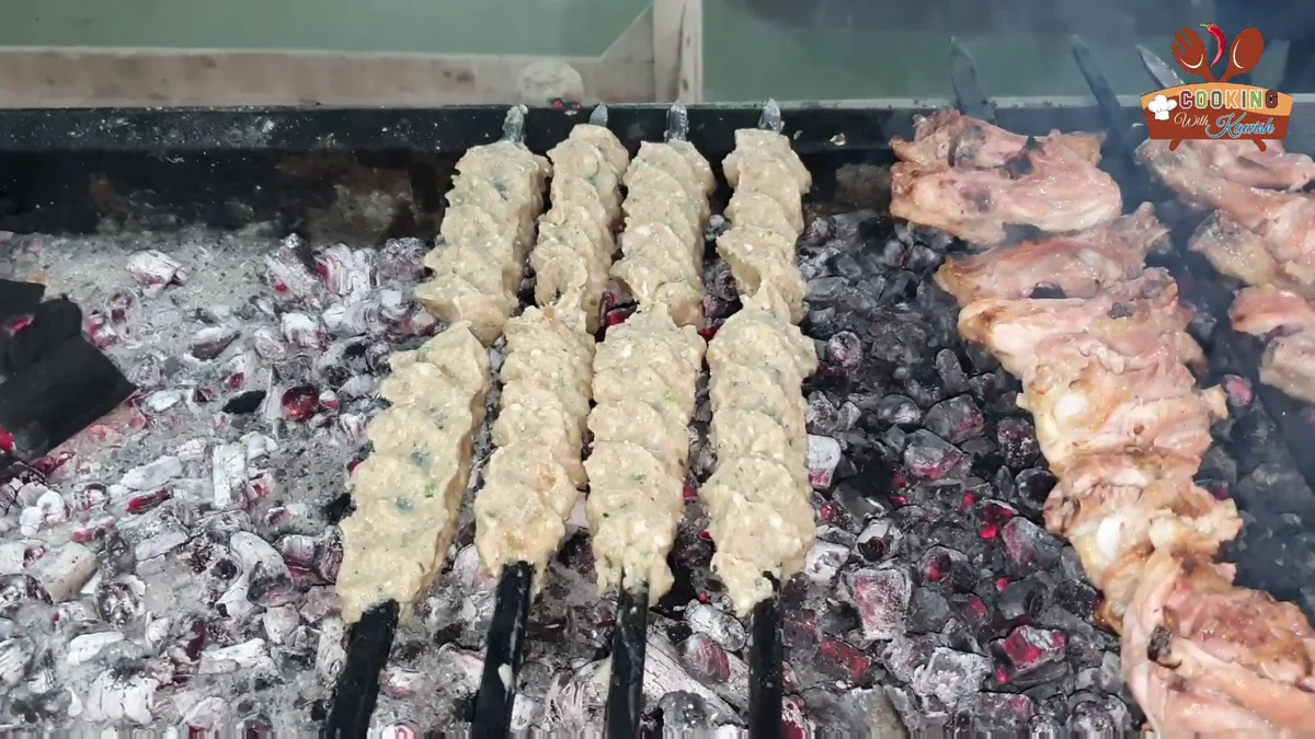 Chicken reshmi kabab skewers grilling over charcoal