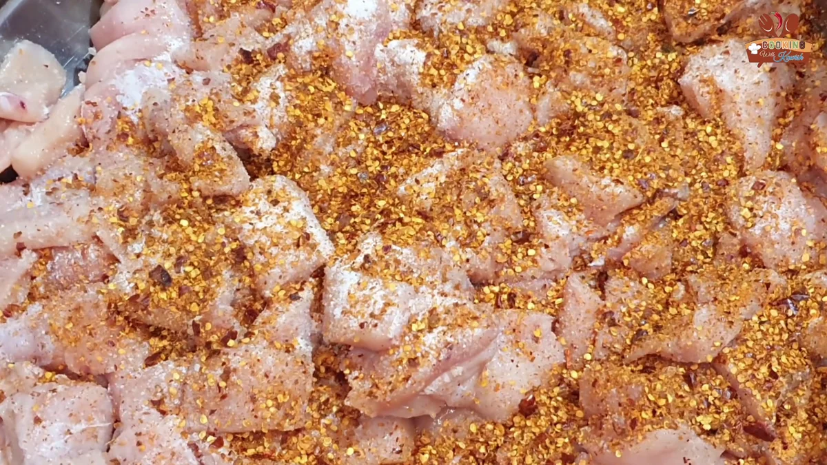 Crushed red chilli flakes sprinkled over the chicken cubes