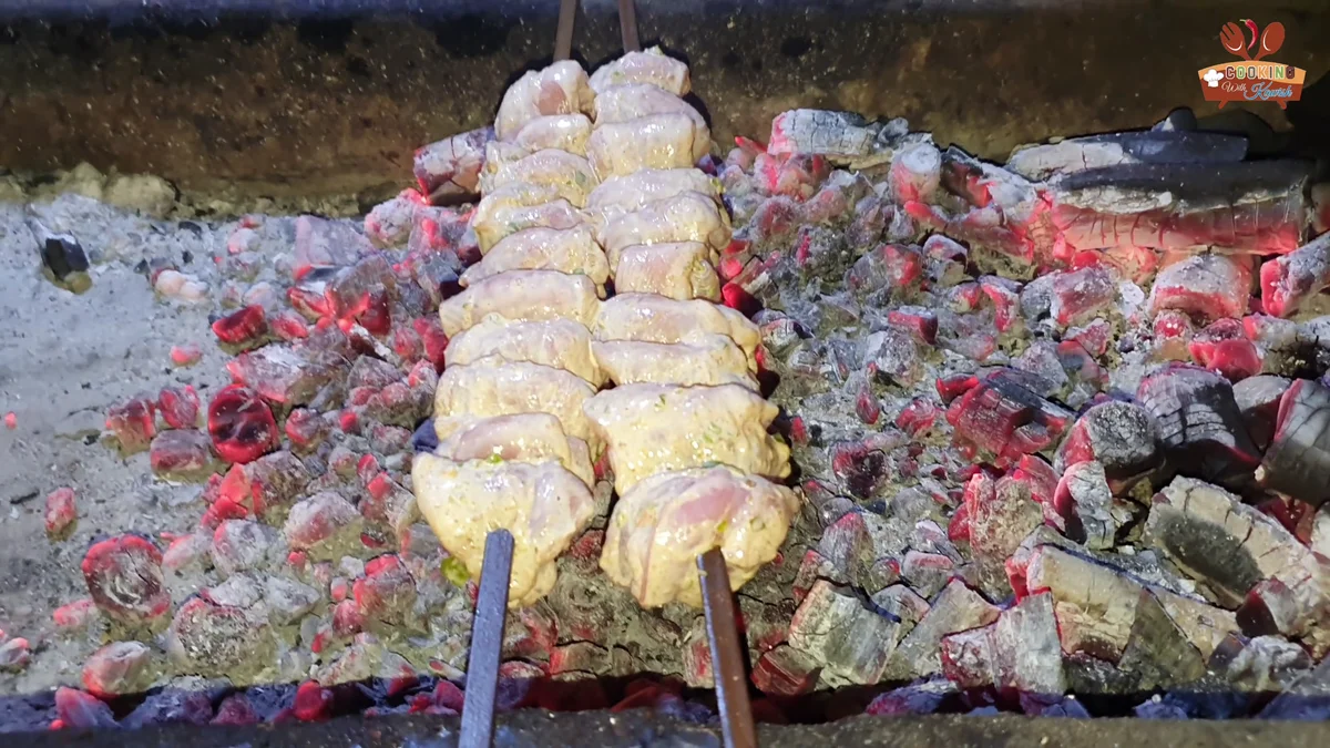 Chicken malai boti skewers starting to cook over charcoal