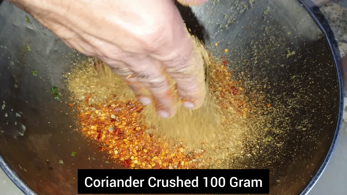 Crushed coriander being added to the spices