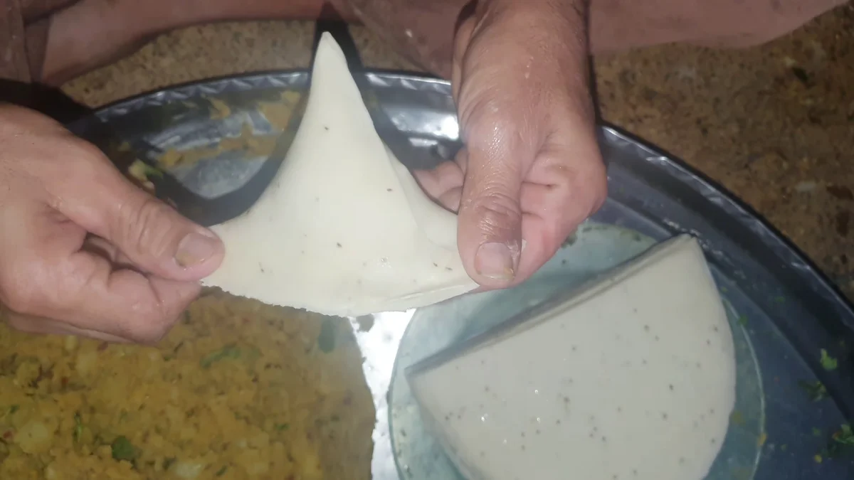 Folding the dough into a pocket and filling it with potato