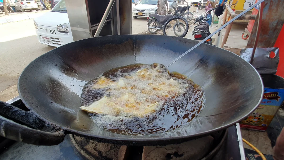 Samosas frying slowly in oil