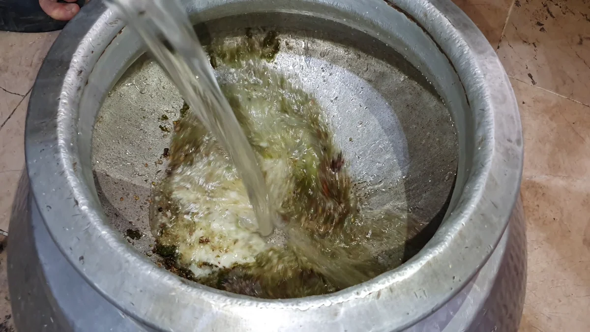 Water being poured into the chicken pulao base