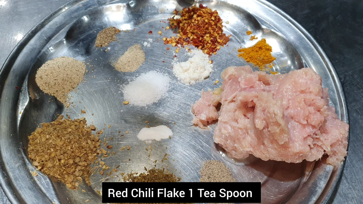 Red chilli flakes added to the chicken mince