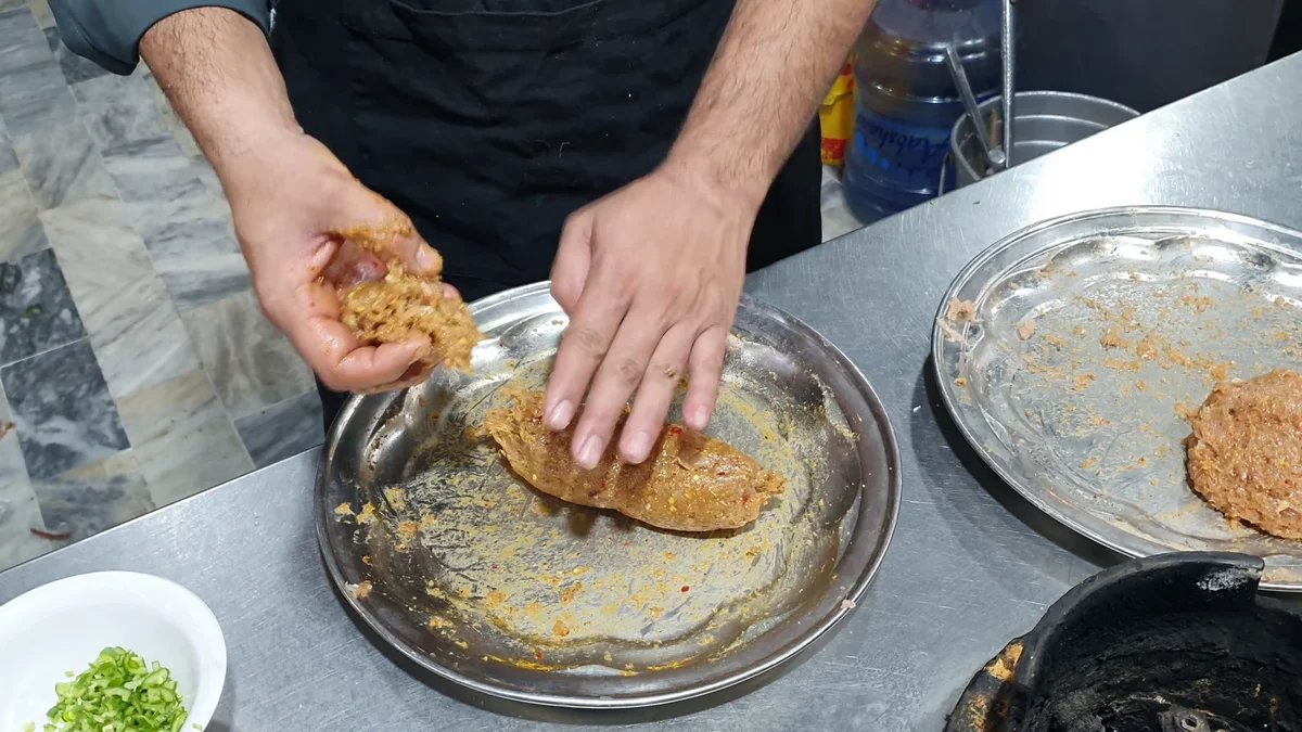 Shaping a chicken ball around a piece of cheese