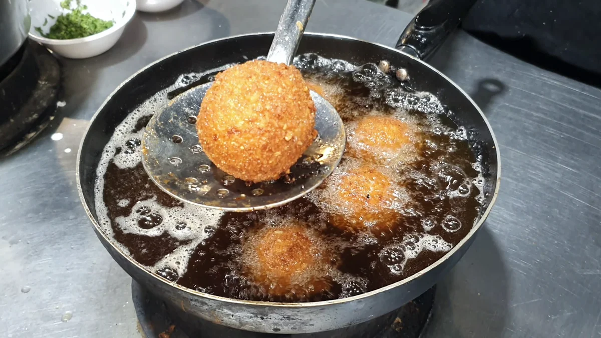 A golden crunchy chicken ball lifted from the oil