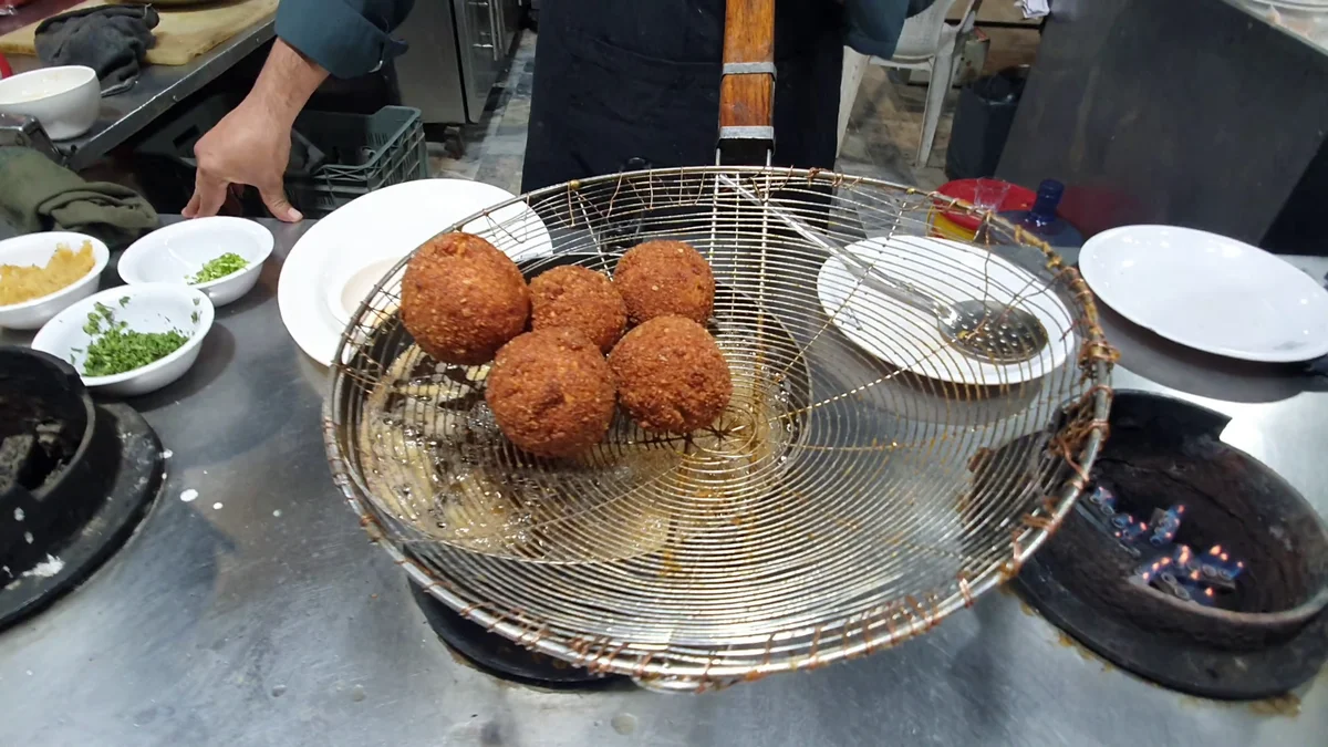 Fried chicken balls draining in a basket