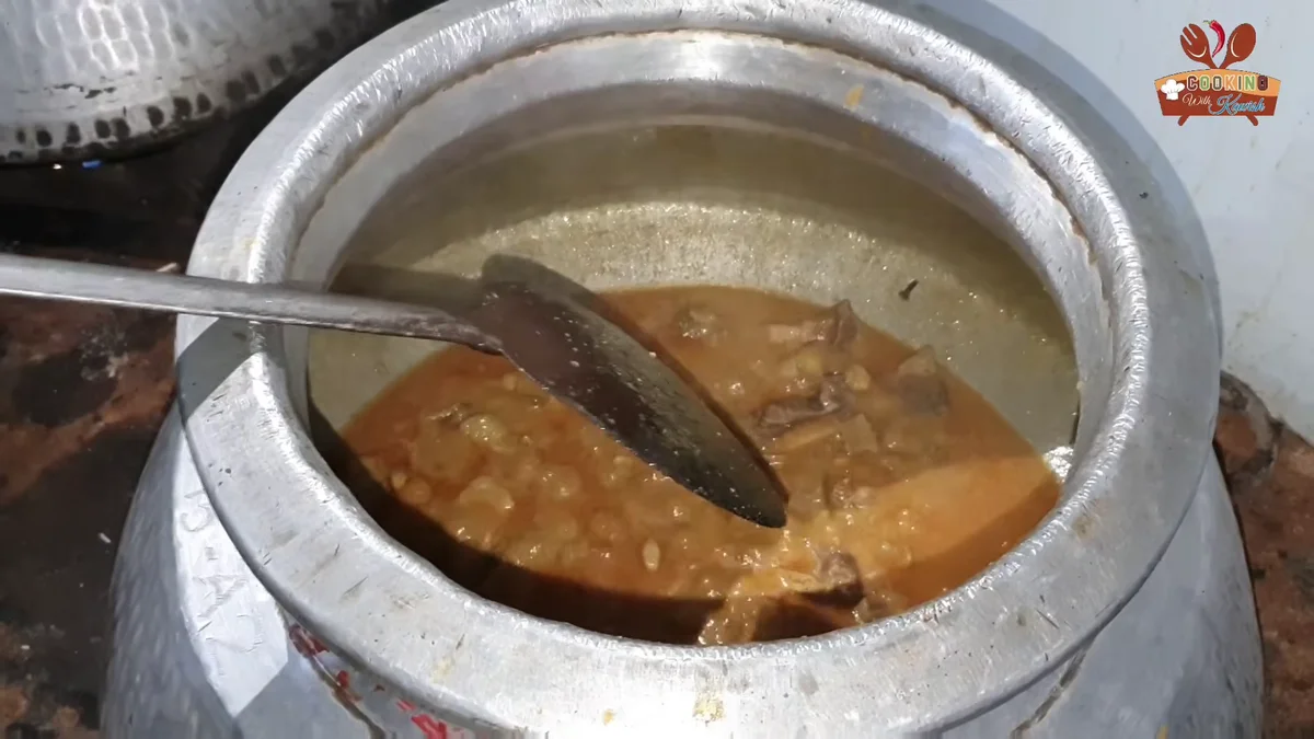 Stirring the beef korma in the deg