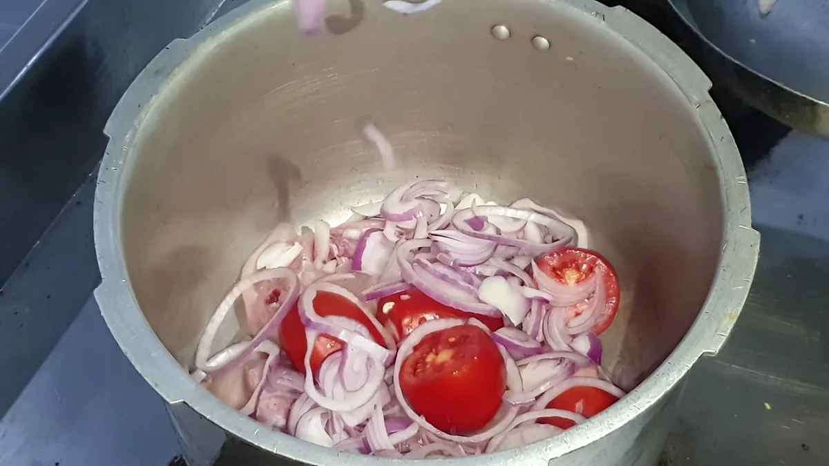 Sliced onions and tomatoes in a pressure cooker
