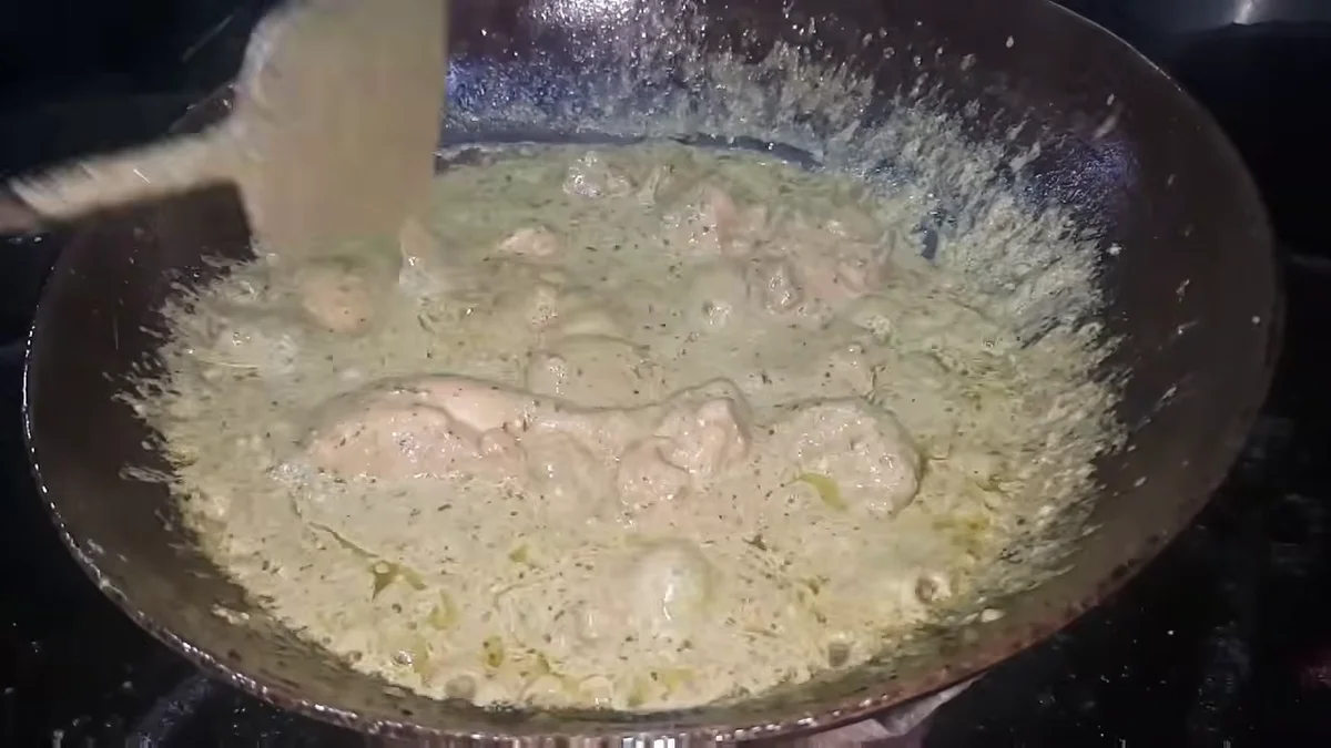 Cream stirred into the green chicken karahi