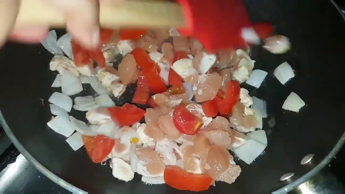 Tomato and chicken cooking together in the pan
