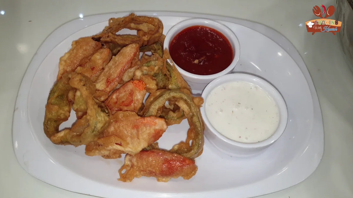 Plate of crispy vegetable tempura with two dipping sauces