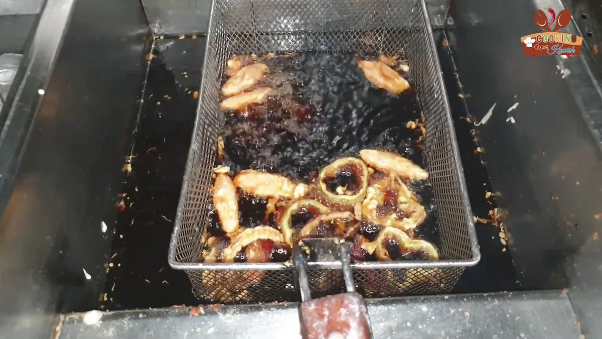 Tempura vegetables frying in a basket in hot oil