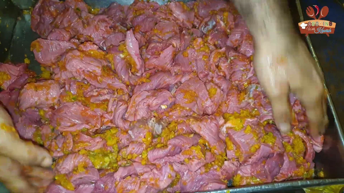 Mixing the paste into the thin Bihari boti beef strips by hand