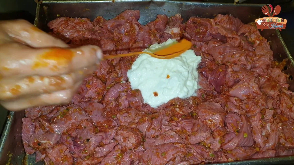 Yogurt and red powder added to the beef strips