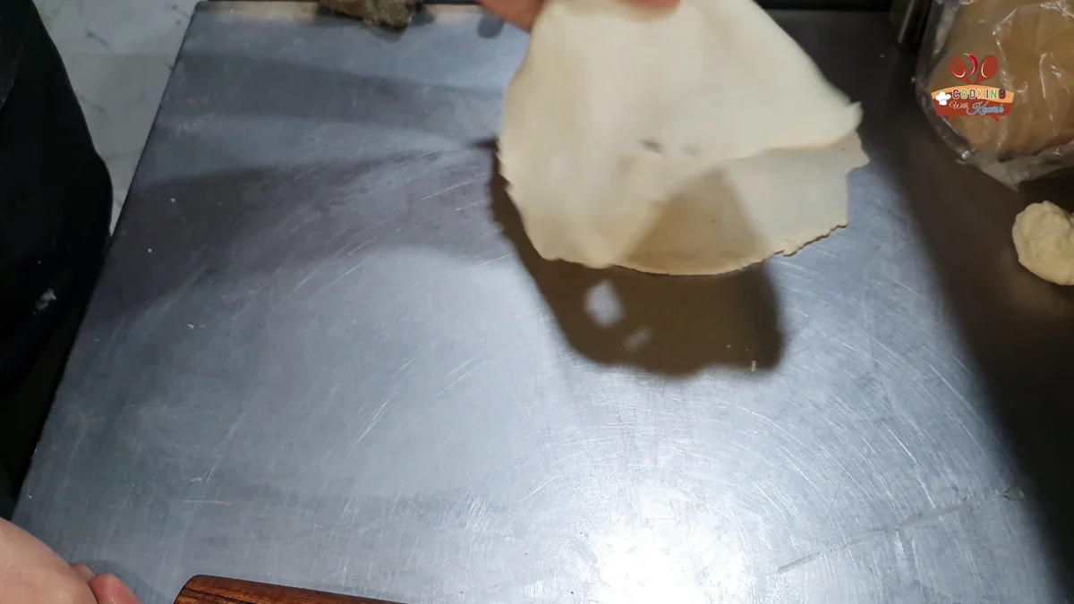 Rolling a dough ball into a thin sheet