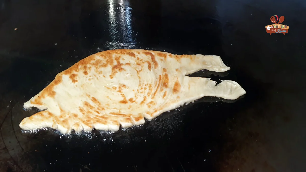 Cheese lachha paratha frying golden on the tawa