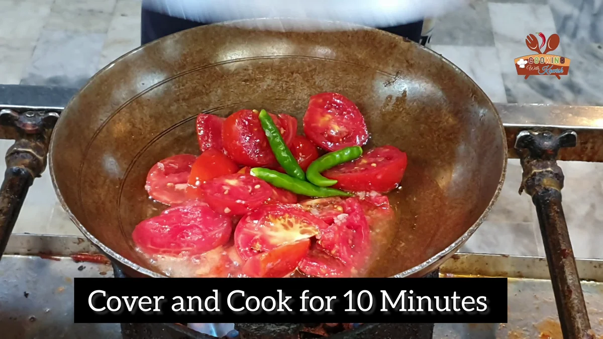Halved tomatoes and green chillies covered to cook for ten minutes