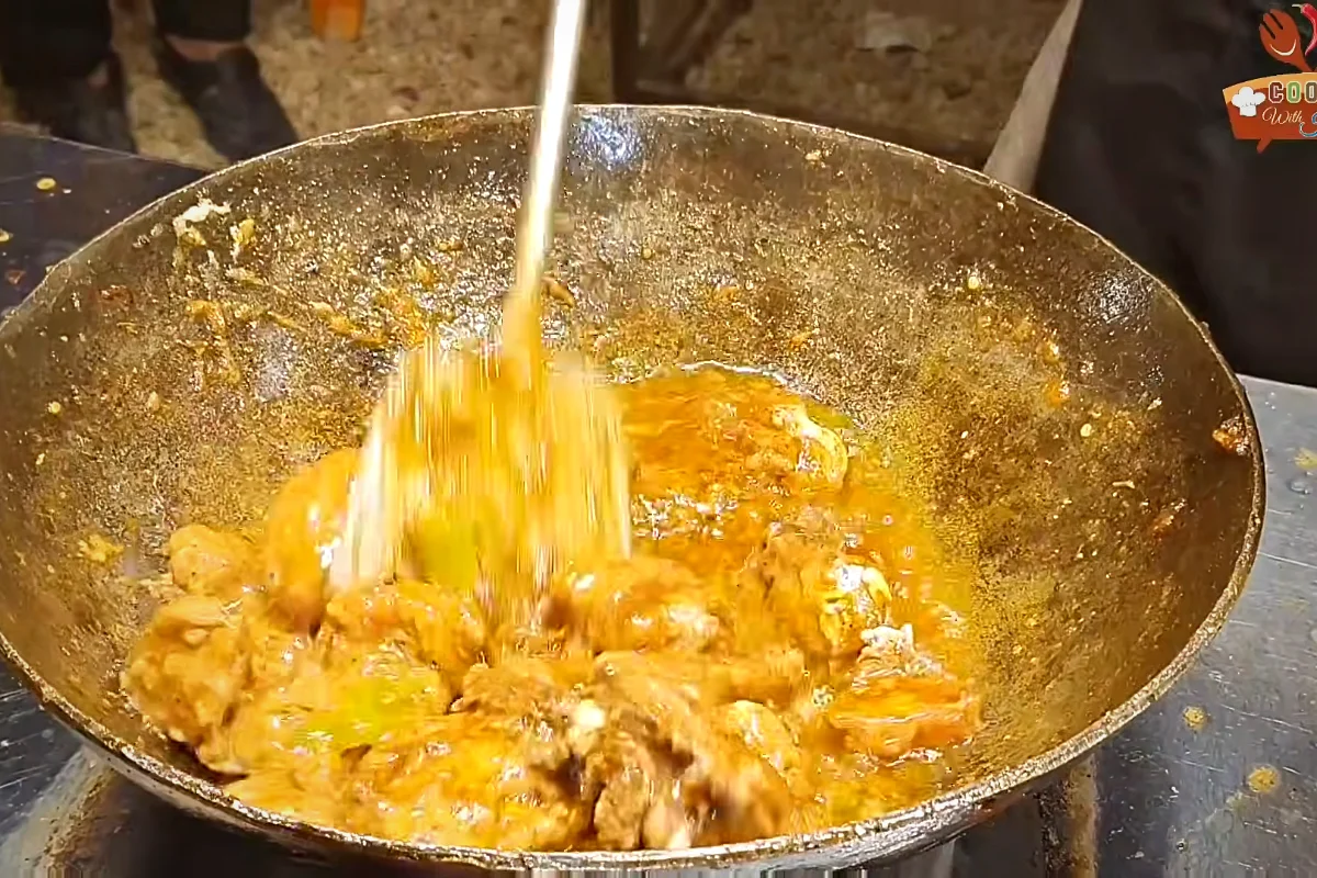 Cream being stirred into chicken karahi