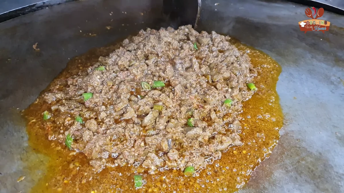 Masaledar tawa fry kaleji with green chillies on a large tawa