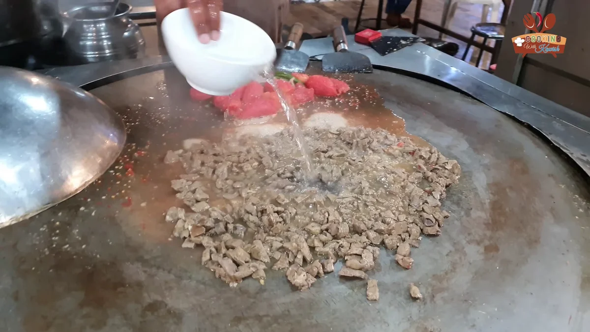 Yogurt poured over the kaleji masala on the tawa