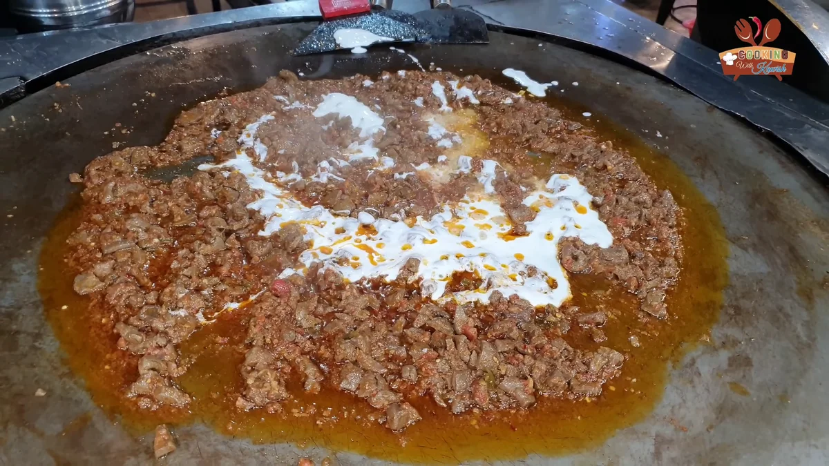 Fresh cream drizzled over the kaleji on the tawa