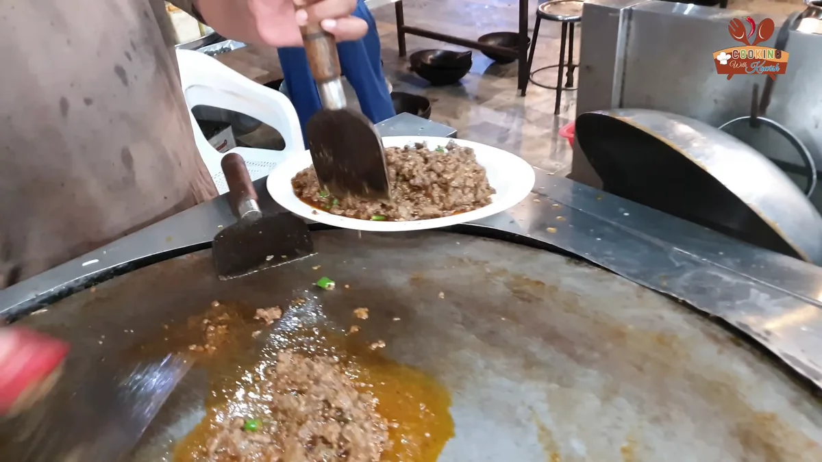 Kaleji being scooped onto a serving plate