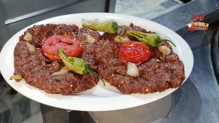 Mutton chapli kababs on a plate with tomato and green chillies