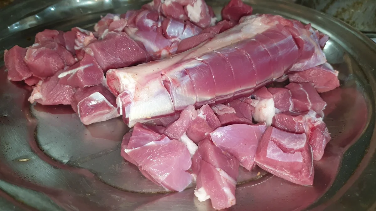 Raw bone-in mutton pieces on a tray