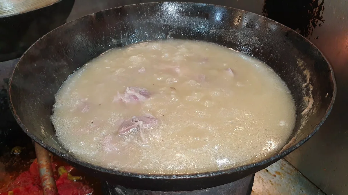 Thick white broth forming around the mutton