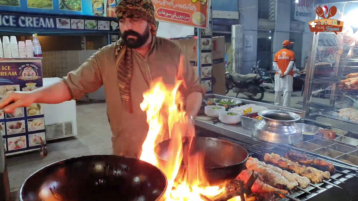 Cook working a karahi over a big flame at the Khan Quetta stall
