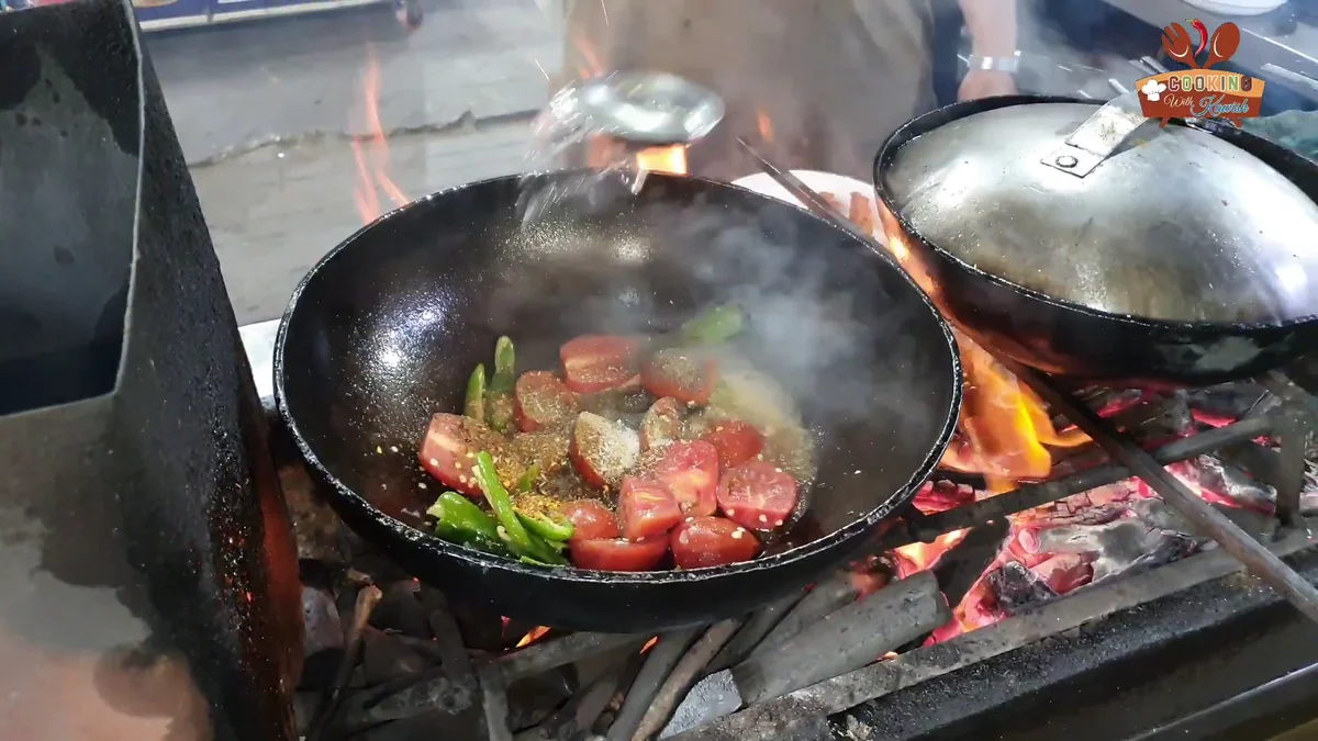 Tomatoes and green chillies cooking down in the karahi