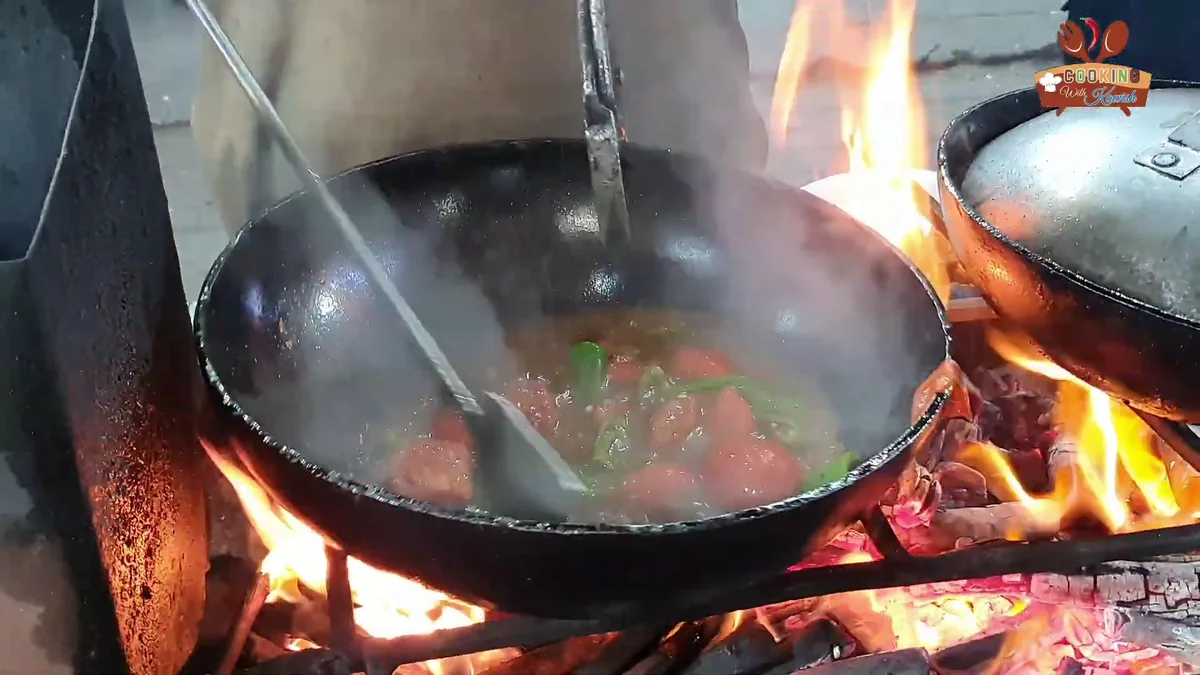 Tomatoes broken down into a gravy in the karahi