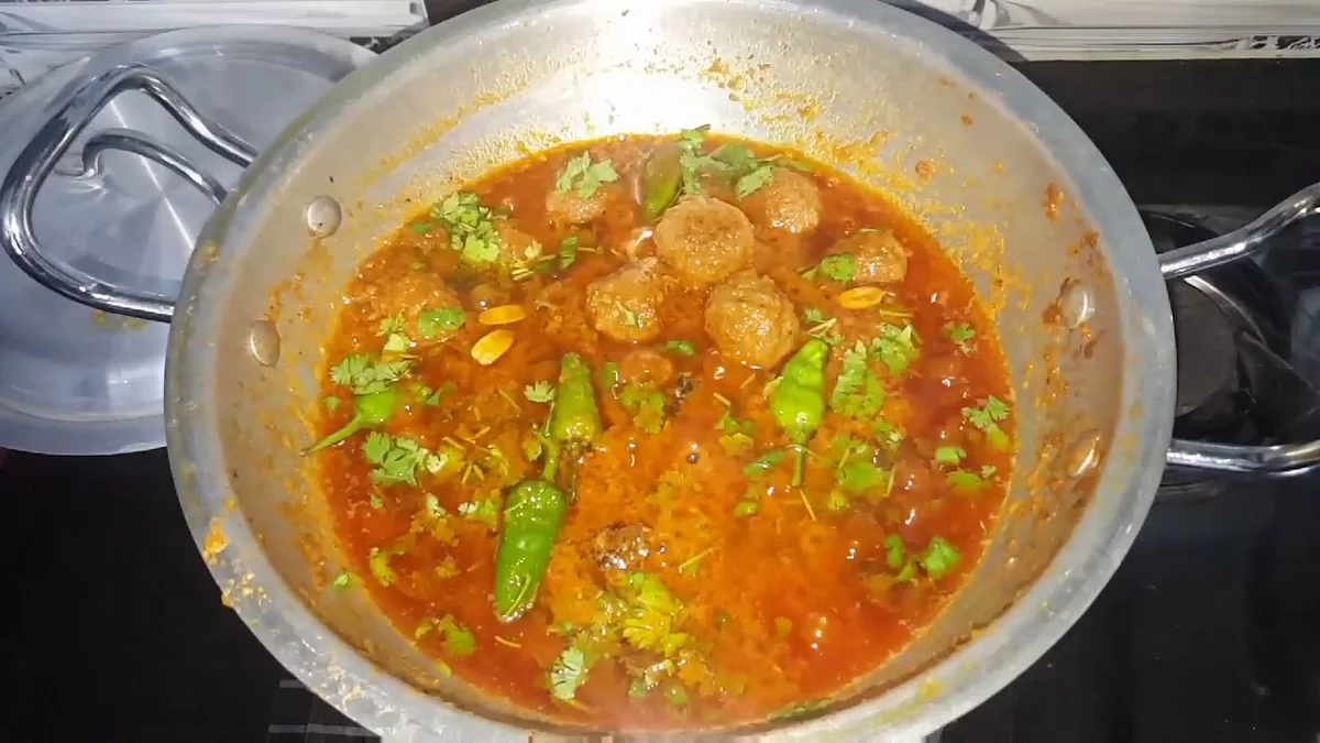 Kofta curry in a karahi with green chillies and coriander