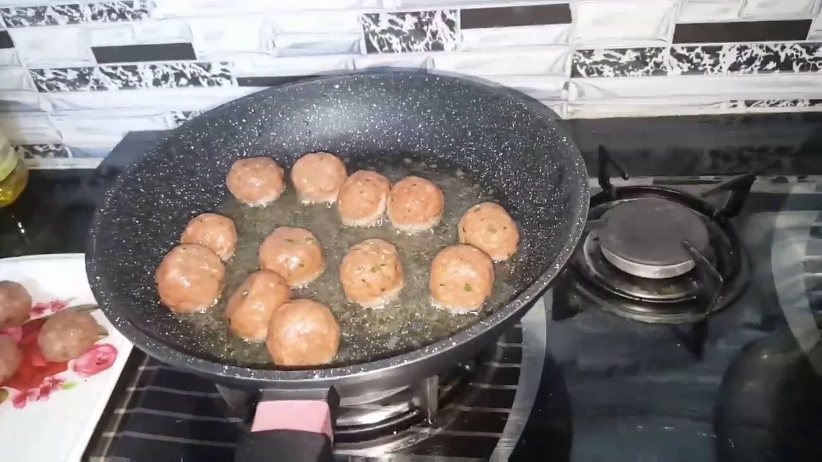 Koftas frying in a non-stick pan
