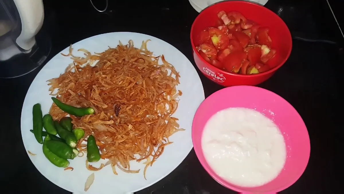 Fried onion, green chillies, tomatoes and yogurt in separate bowls