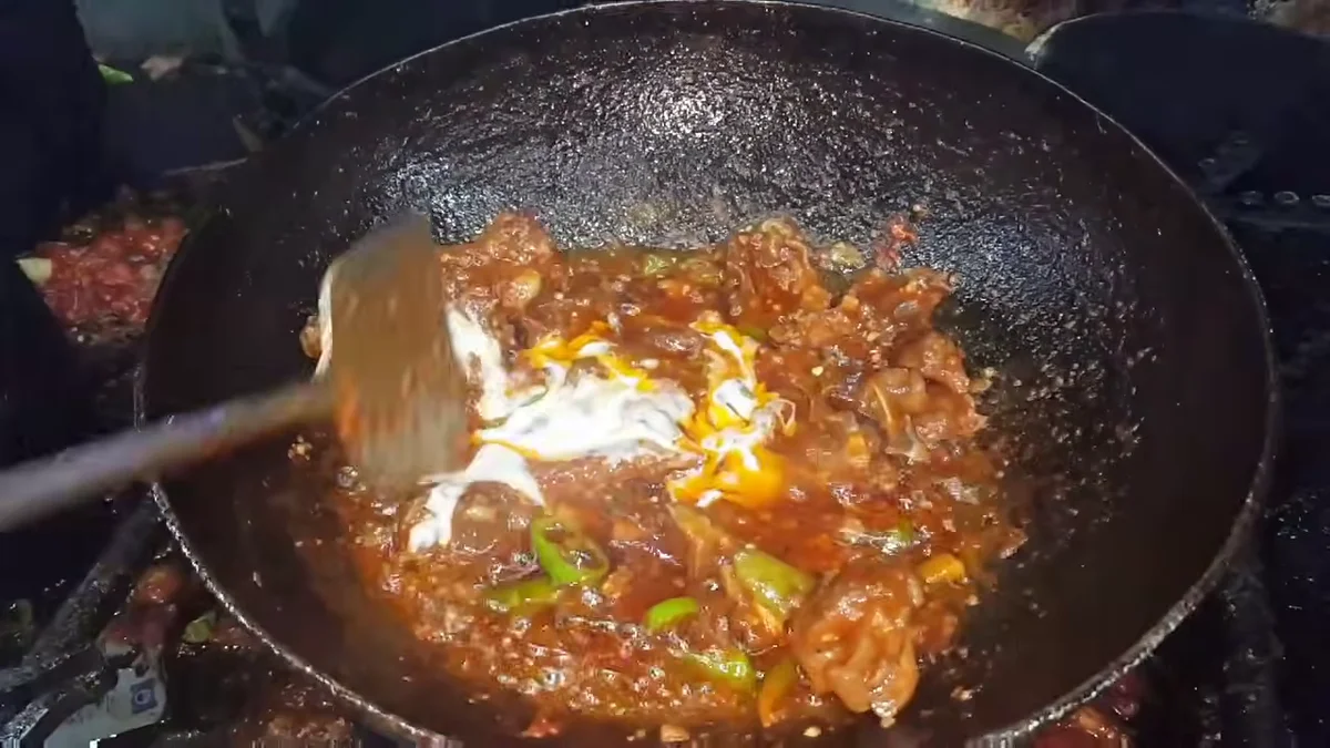 Yogurt being stirred into the karahi