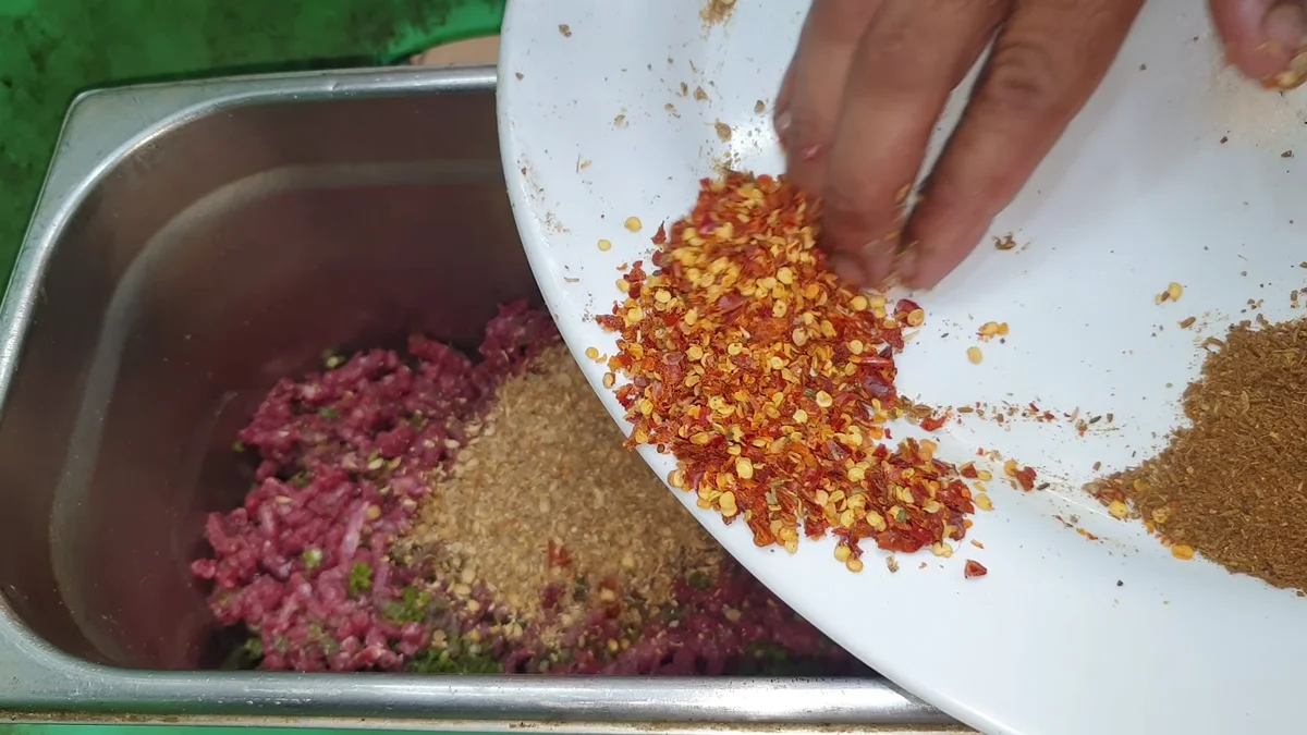 Red chilli flakes added to the chapli kabab mince