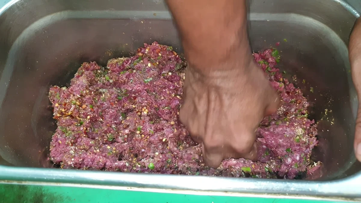 Mixing the spices into the mince by hand