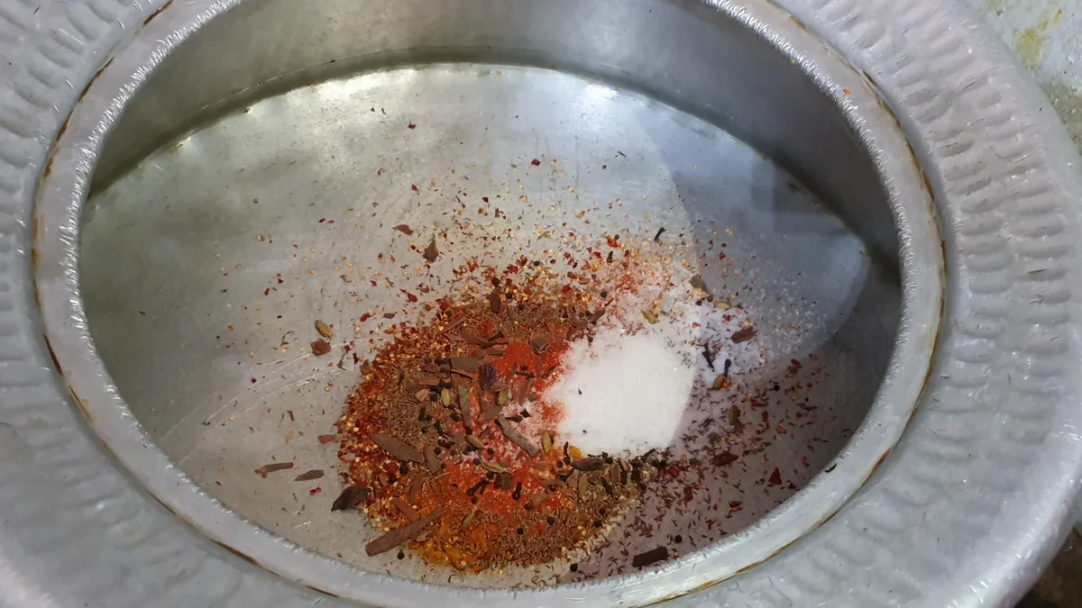 Salt being added to the spices in the deg