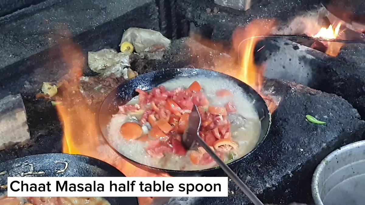Chaat masala sprinkled over the tomatoes in the karahi