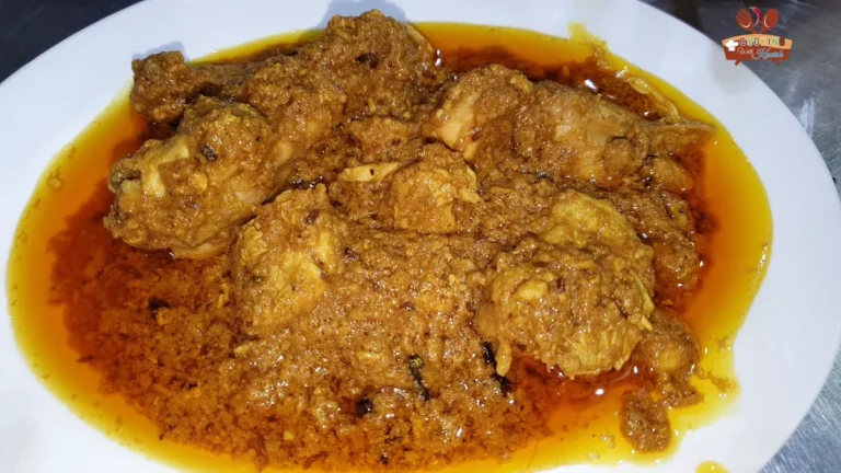 Plate of Asad Pakwan danedar chicken korma in a red oily gravy