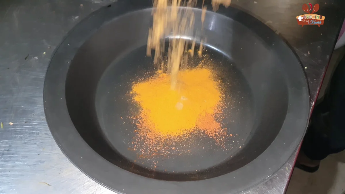 Red chilli and turmeric spices added to the pot