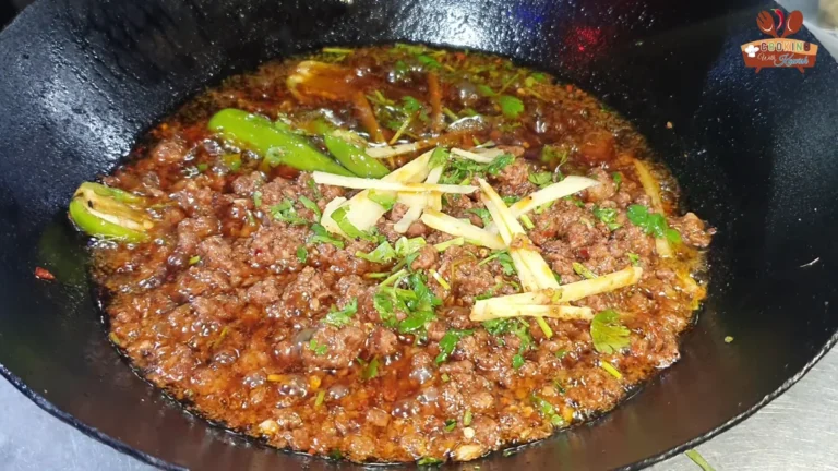 Dum keema in a karahi topped with ginger julienne and green chillies