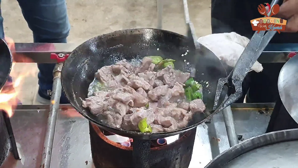 Green chillies added to the mutton in the karahi