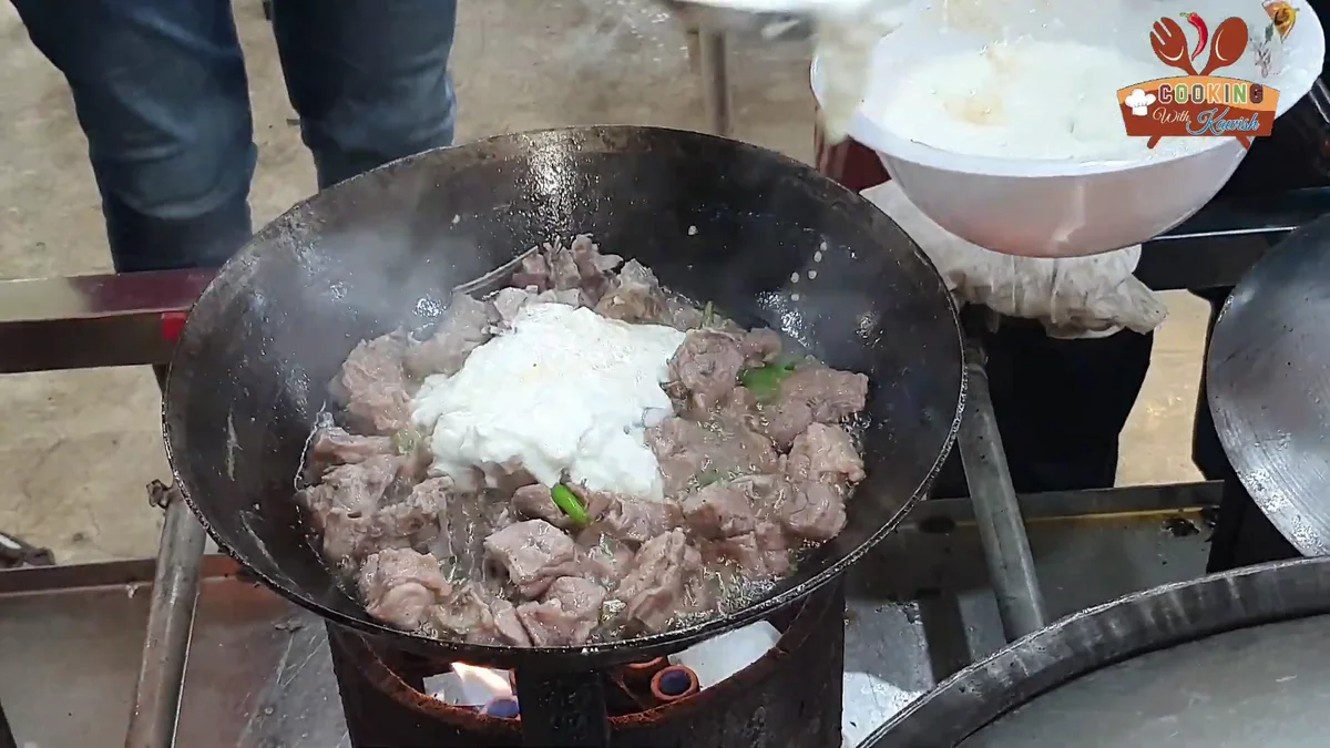 Yogurt being added to the mutton in the karahi