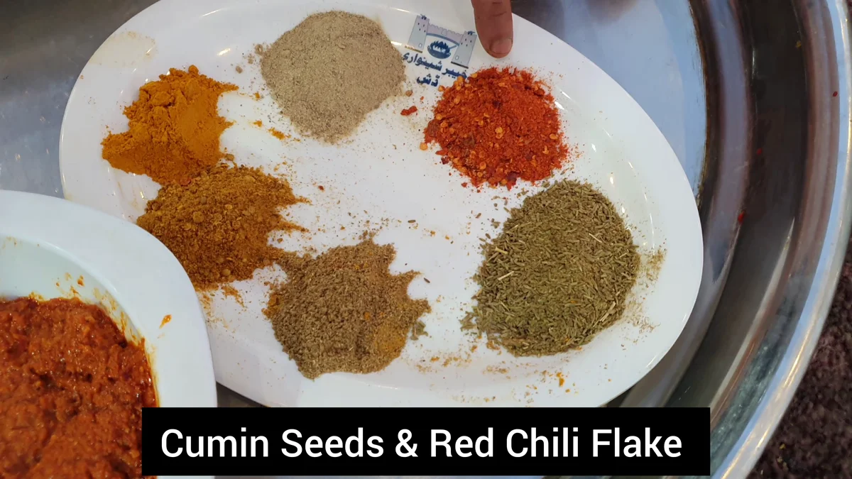 Plate of ground spices labelled cumin seeds and red chilli flakes